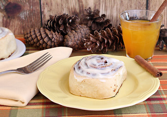 Image showing Delicious Cinnamon Bun with a glass of apple cider.