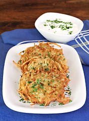 Image showing Potato Latkes and sour cream, vertical.