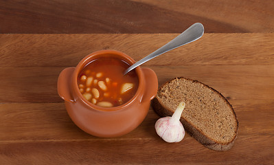 Image showing Soup in clay pot with bread and garlic