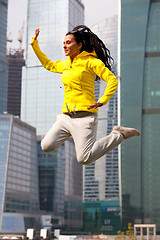 Image showing brunette in a yellow blazer jumping