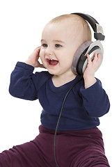 Image showing young child with ear-phones listening to music