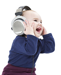 Image showing young laughing child with ear-phones listening to music