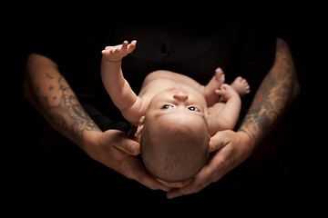 Image showing Hands of Father and Mother Hold Newborn Baby on Black