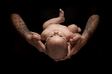 Image showing Hands of Father and Mother Hold Newborn Baby on Black