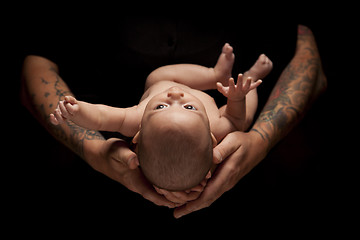 Image showing Hands of Father and Mother Hold Newborn Baby on Black