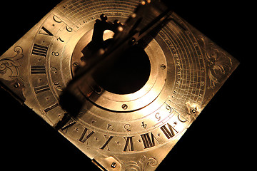 Image showing very old golden sundial beneath