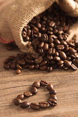 Image showing Grains of coffee on a wooden surface