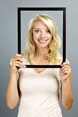 Image showing Smiling woman with picture frame