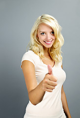 Image showing Smiling woman giving thumbs up