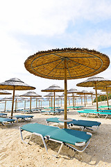 Image showing Beach umbrellas and chairs on sandy seashore