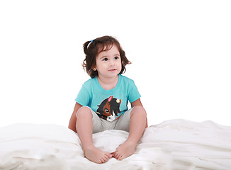 Image showing Curly toddler girl in bed, looking into camera 