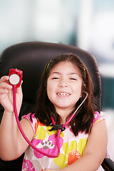 Image showing Cute little girl is playing doctor with stethoscope, isolated ov