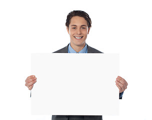 Image showing Happy businessman showing an emty billboard