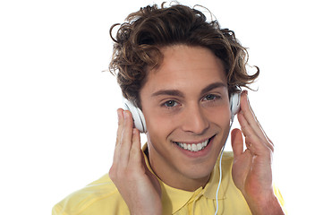 Image showing Casual young man listening music with headphones