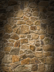 Image showing Brown masonry rock wall lit dramatically 