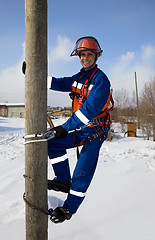 Image showing Electrician on a pole in a good mood