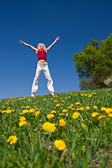 Image showing young woman in red outfit having fun on meadow