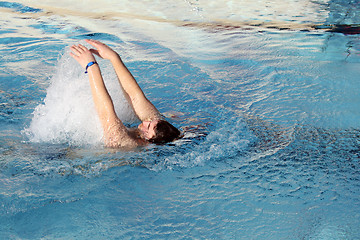 Image showing young man swimming backstroke in pool