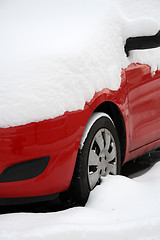 Image showing red car covered with snow in winter 