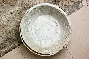 Image showing Grungy bucket on unfinished flooring