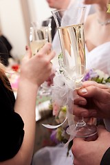 Image showing wedding decorated glasses in hands of groom and bride 