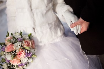 Image showing hands of groom and bride with wedding bouquet