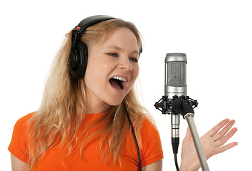 Image showing Singer in headphones singing with the microphone