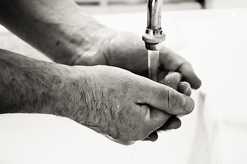 Image showing Hands washing in basin