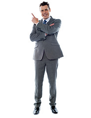 Image showing Businessman in suit pointing at copyspace