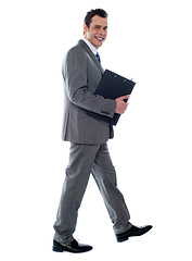 Image showing Businessman holding documents and walking