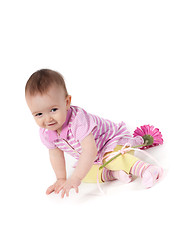 Image showing Cute baby girl in pink with gerbera
