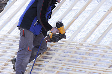 Image showing roofer working on a new roof in wood