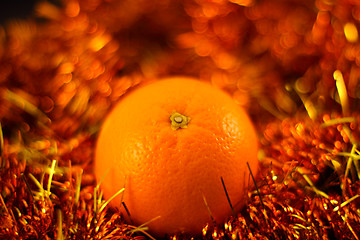 Image showing orange close up on a background of twinkling garlands