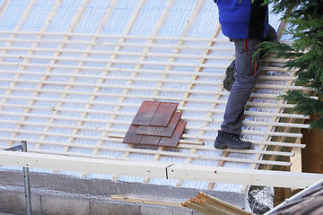 Image showing roofer working on a new roof in wood