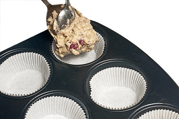 Image showing filling a muffin tray