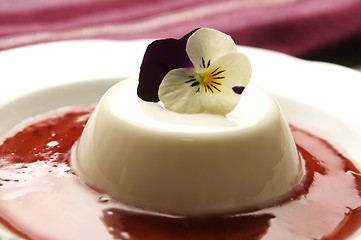 Image showing Vanilla panna cotta with berry sauce and spring flower