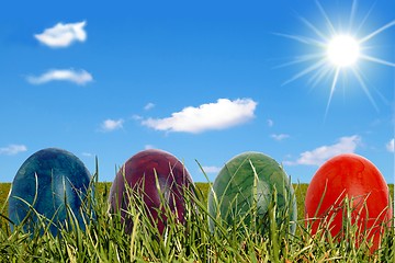 Image showing Four easter eggs with sun and clouds