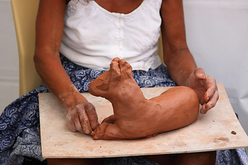 Image showing Sculptor woman creating a horse slept in clay