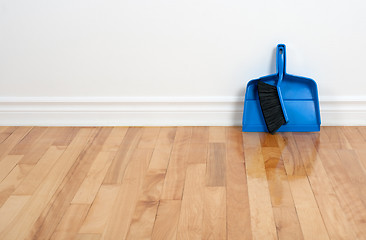Image showing Dustpan and brush on a wooden floor