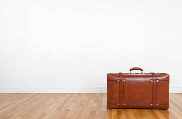 Image showing Vintage leather suitcase on a wooden floor
