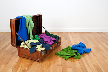 Image showing Leather suitcase full of colorful clothing