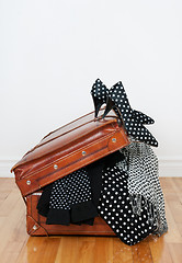 Image showing Polka dot clothing in a vintage leather suitcase