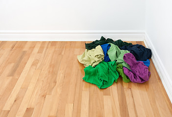 Image showing Pile of bright clothes in the room corner