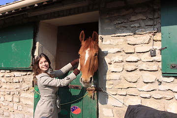 Image showing pretty young woman giving food to horses