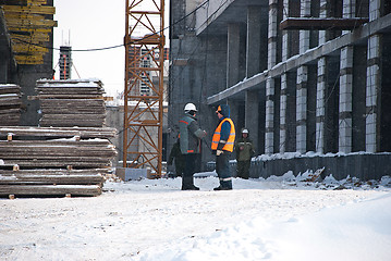 Image showing Two Builders at the Construction Site in Winter Between Multi Storey Buildings Under Construction