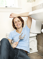 Image showing Woman fixing plumbing