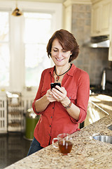 Image showing Woman using cell phone at home