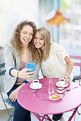 Image showing Woman showing phone to friend