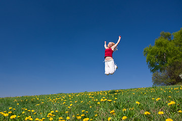 Image showing young woman in red outfit having fun on meadow