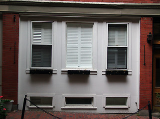 Image showing three white windows in a red brick building